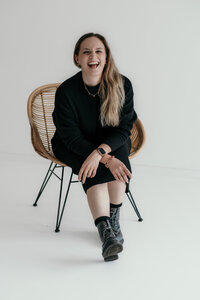 Wedding Photographer Karin sits laughing on a chair.
