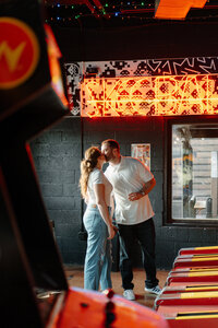 couple kissing in a downtown arcade