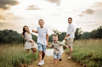 Family of 4 playing in an open field. Photographed by Jenni Nikki- Atlanta Family Photographer.