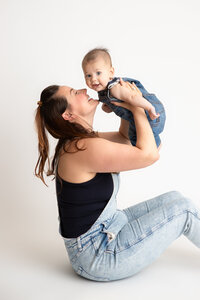Edmonton studio photo of mom and baby boy sitting on white savage seamless paper