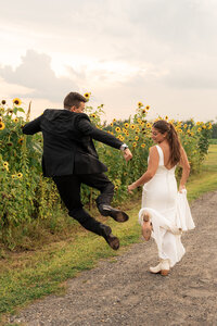 a bride and groom running in a sunflower field in central new jersey