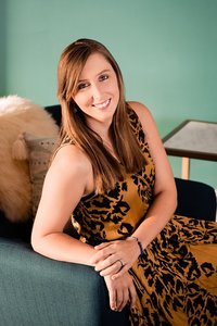 Woman wearing a mustard colored dress and smiling