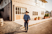 Senior Photography, boy walking across road with a cowboy hat