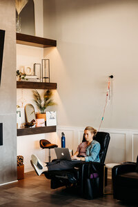 Woman receiving IV therapy in a lounge area