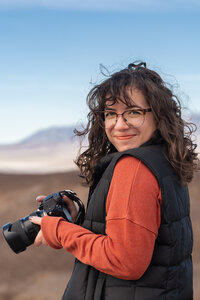 A person smiling and holding a camera