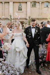 Bride and Groom walking down the aisle just married with flower petals thrown in the air