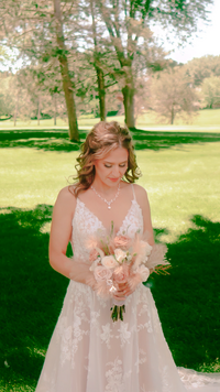 bride looks at her bouquet outdoors in st cloud mn