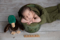 Example of newborn session, baby is posed in bucket while sleeping