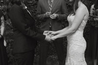 A close up of two people holding hands during their wedding ceremony 