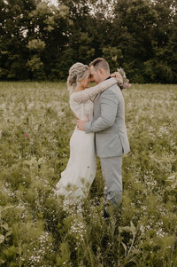 Bride and groom about to kiss in a field