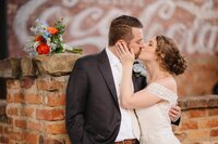 A newlywed couple holding and kissing each other