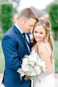 Groom joyfully smiles on his wedding day as holds on to his new bride