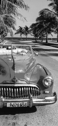 Ein Oldtimer steht an einer Straße von Kuba