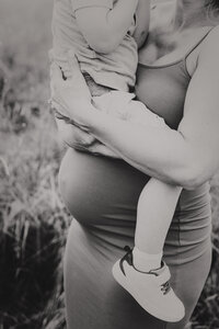 mother holding son over pregnant belly