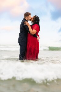 Couple kissing in the waves in San Diego