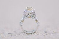 Yellow Sapphire and Diamond ring with a scroll of diamonds on either side of the center stone with three yellow bezel set sapphires