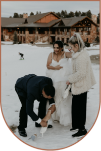 bride, groom and wedding photographer changing brides shoes on wedding day