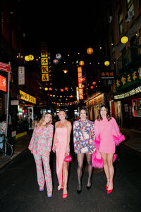 four women stand in street