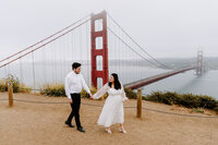 couple walking with Golden gate bridge in background