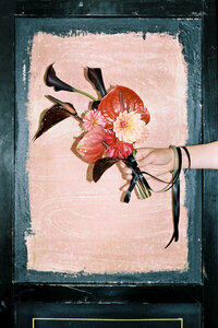 editorial style 35mm film photo of a bride holding a petite red floral bouquet
