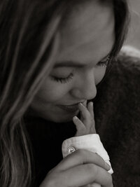 Close-up of a mother kissing her newborn’s tiny fingers, captured in black and white to preserve the emotional stillness of the moment.