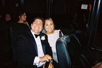 Flash photo of bride and groom sitting together on bus