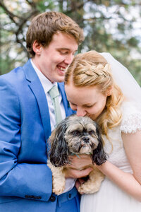 Bride and groom hold onto their dog during their wedding portraits in Yosemite
