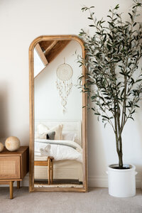 dreamcatcher reflected in a stand up mirror in a bedroom with an olive tree