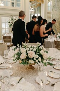 Wedding Photographer in VA | centerpiece on reception table with guests moving in the background