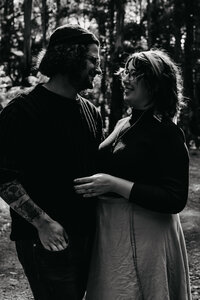 black and white of couple at their engagement shoot in the forest
