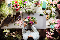 Woman putting together floral arrangements for florist business