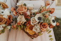 A person in a wedding dress holding a colorful bouquet of flowers 