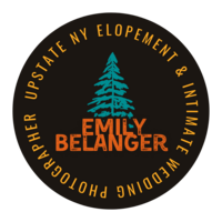 A dark grey circle badge stating "Upstate NY Elopement & Intimate Wedding Photographer" in yellow text circles a teal pine tree that tops bold orange lettering stating "Emily Belanger"