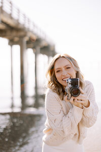 Photographer, Katie Elizabeth, poses on beach