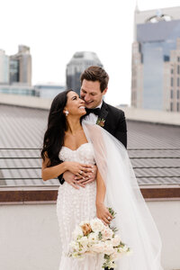bride and groom embracing on rooftop