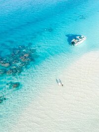 Aerial view couple and boat with the blue lagoon in Tahaa island