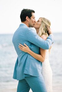 Newlyweds share their first kiss as husband and wife on the beach at Casa de Campo Resort in the Dominican Republic, captured on film by Asia Pimentel Photography