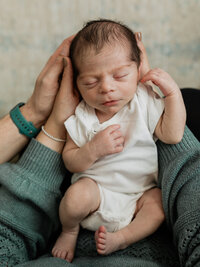 newborn baby boy held by mom and dad