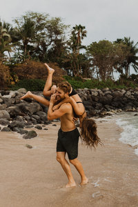 man &  woman kissing on rocks