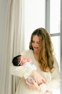 A newborn baby boy wearing white on a white blanket, taken by Amsterdam photographer, Sim Sawyers.