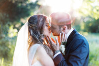 Sunset kiss in minnesota wedding  with bride and groom soaking in lens flare while they share intimate moment. 