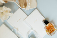 Flat lay of shoes and wedding invites.