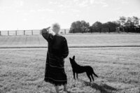 Sasha looking into the fields with dog by her side