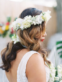 Hawaii wedding bridal portraits with tropical white flower crown in brides hair and a bold red lip bridal makeup with a curly bridal hair style photographed at couples estate wedding by Tulsa Wedding Photographer Laura Eddy