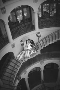 Bride and groom embrace on a winding staircase