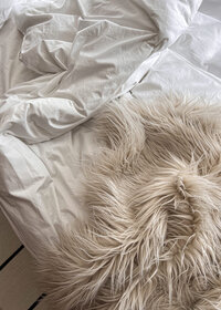 soft fluffy vanilla colored blanket on a bed