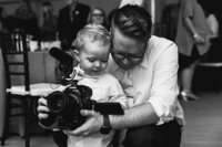 Videographer shows camera to little boy