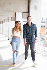 An Austin wedding photographer captures a couple walking through a parking garage during their engagement session.