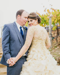 Bride + Groom face each other as Bride turns over her left shoulder looking at the camera