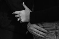 Close up view of two people arms wrapped around each other showing off an engagement ring